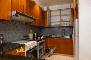 a kitchen with wooden cabinets and a stove top oven at Central Park towers residence difc in Dubai