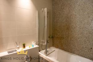 a bathroom with a shower and a tub and a sink at Central Park towers residence difc in Dubai +44 photos
