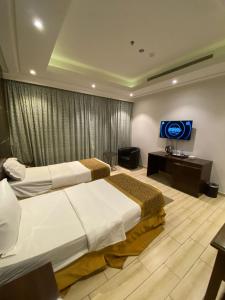 a hotel room with two beds and a flat screen tv at Gardenia Park Quraish hotelفندق جاردينا بارك قريش in Jeddah
