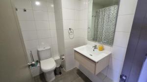a white bathroom with a toilet and a sink at Departamento Studio en pleno centro de Concepción in Concepción