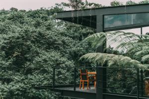 a wooden chair sitting on the balcony of a house at Bio Habitat Hotel, AKEN SOUL Collection in Armenia