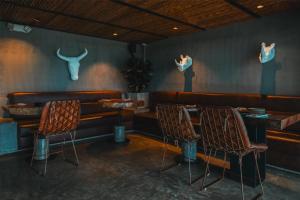 a restaurant with three chairs and a wall with two bulls at Bio Habitat Hotel, AKEN SOUL Collection in Armenia