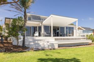 a white house with a porch and lawn at Cliff Top Retreat in San Remo