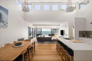 a kitchen and dining room with a table and a couch at Cliff Top Retreat in San Remo