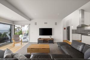 a living room with a couch and a tv at Cliff Top Retreat in San Remo