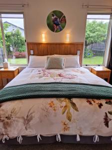 a bedroom with a large bed and two windows at Blue Ridge Studios and Bed & Breakfast in Te Anau