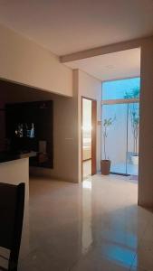 a living room with a large glass door with a plant at Casa confortável com garagem coberta in Primavera do Leste