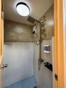 a bathroom with a shower with a light on the ceiling at Nipa Hut Lodging House in Coron