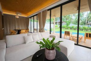 a living room with a white couch and a table at AVA Aurora Villa in Wok Tum