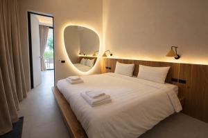 a bedroom with a large white bed with a mirror at AVA Aurora Villa in Wok Tum