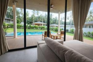 a living room with a couch and a view of a pool at AVA Aurora Villa in Wok Tum +11 photos
