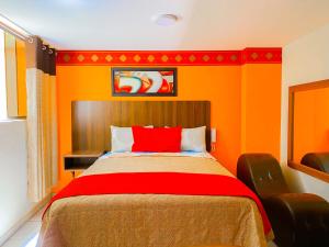 a bedroom with orange walls and a bed with a red pillow at Hostal Mayra Breña in Lima +28 photos