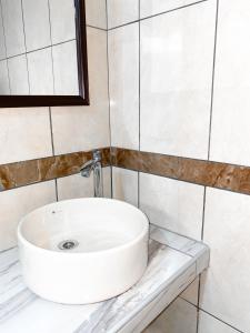 a white sink sitting on a counter in a bathroom at Hostal Mayra Breña in Lima