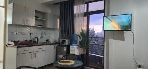 a kitchen with a large window and a television at Mardley Suites in Nairobi