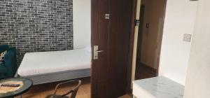 a small bedroom with a bed and a brick wall at Mardley Suites in Nairobi +3 photos