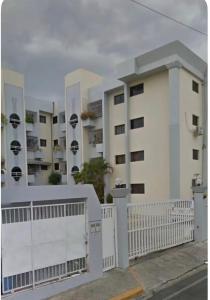 a white building with a white fence in front of it at madrigal 1-3br with parking in Santiago de los Caballeros