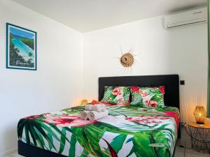a bedroom with a bed with a green and white comforter at Private beach access, fiber optic internet & parking in Punaauia