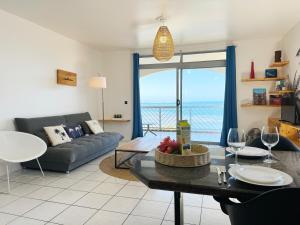 a living room with a couch and a table with wine glasses at Private beach access, fiber optic internet & parking in Punaauia
