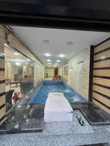 a large swimming pool in a building with at Villa- Alahlam in Ghaţāţī