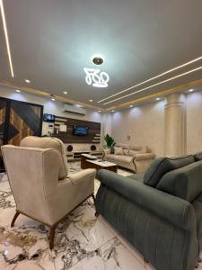 a large living room with couches and a tv at Villa- Alahlam in Ghaţāţī +49 photos