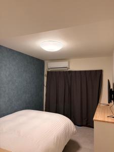 a bedroom with a white bed and a window at hotel LUNA STELLA in Sendai