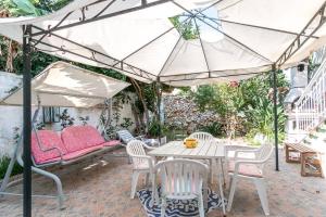 un patio con mesa, sillas y sombrilla en Villino Claudia, en Porto Cesareo