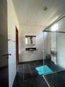 a bathroom with a glass shower and a sink at Casa ao ar livre in Aracaju