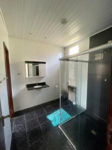 a bathroom with a glass shower and a mirror at Casa ao ar livre in Aracaju