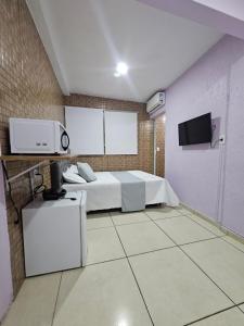 a bedroom with a bed and a tv in it at Alice Suites in Arraial do Cabo
