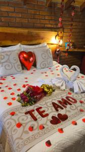 a bed with hearts and flowers on it at Pousada das Castanheiras in Monte Verde
