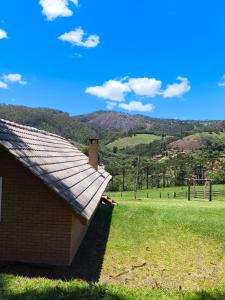 a roof of a building in a field with mountains in the background at Pousada das Castanheiras in Monte Verde