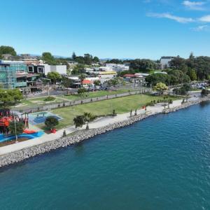 an aerial view of a city next to a body of water at Kiwi Cove in Tauranga