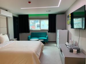 a hotel room with a bed and a blue couch at Hotel Kaya Puerto Galera in Sabang