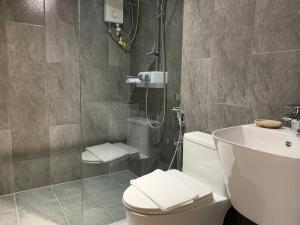 a bathroom with a shower and a toilet and a sink at Hotel Kaya Puerto Galera in Sabang +59 photos