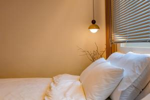 a bed with white pillows in a room with a window at Sinnonhyeon Station 5minutes, Gangnam Plastic Surgery, Severance Hospital, COEX, airport bus 5minutes, Hongdae 30minutes, Itaewon 15minutes, 명동 30minutes in Seoul