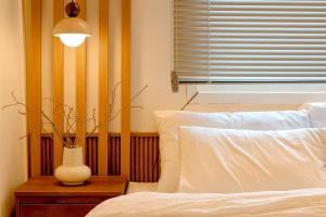 a bedroom with a bed and a vase on a table at Sinnonhyeon Station 5minutes, Gangnam Plastic Surgery, Severance Hospital, COEX, airport bus 5minutes, Hongdae 30minutes, Itaewon 15minutes, 명동 30minutes in Seoul