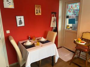 a dining room with a table and a red wall at De Drie Populieren in Losser +12 photos