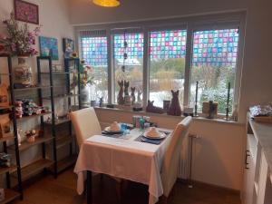 a dining room with a table and chairs and stained glass windows at De Drie Populieren in Losser