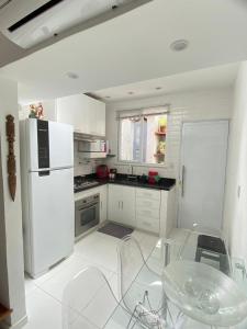 a kitchen with a white refrigerator and a table and chairs at MATER Vila Borges in Rio de Janeiro