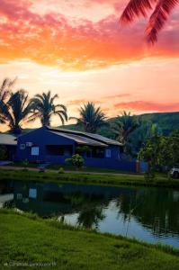 a house with a pond in front of a sunset at casa completa Paraiso valle verde in Estivado