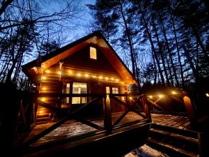 a small cabin with lights on the porch at night at Secret Base Mysa シークレットベース ミーサ 星の街399 in Tsumagoi