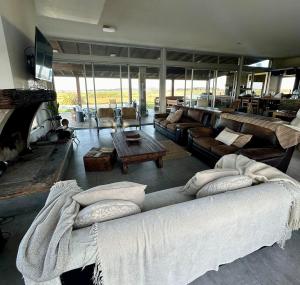 a living room with a large couch with pillows on it at Chacra para 13! A 20min Punta del Este - Starlink in Maldonado +72 photos