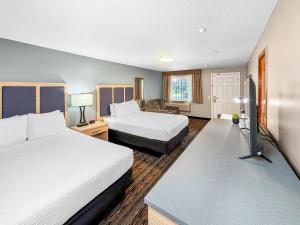 a hotel room with two beds and a television at Courtesy Inn Downtown Eugene in Eugene +17 photos