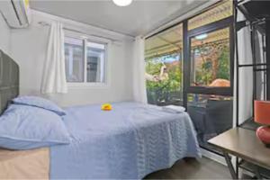 a bedroom with a blue bed and a window at Monkey Houses in Matapalo +20 photos