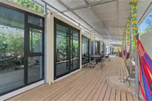 a building with a deck with tables and windows at Monkey Houses in Matapalo