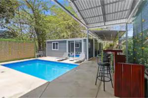 a backyard with a swimming pool and a bar at Monkey Houses in Matapalo