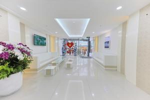 a hallway with flowers and benches in a building at Sea Light Hotel Nha Trang Beach in Nha Trang