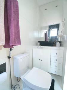 a bathroom with a white toilet and a purple towel at MATER Vila Borges in Rio de Janeiro +22 photos