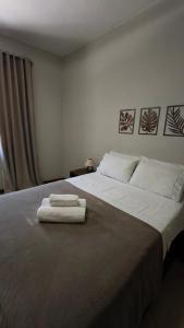 a bedroom with a bed with two towels on it at Apartamento Luxo Centro Paty do Alferes in Paty do Alferes