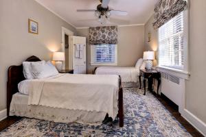 a bedroom with two beds and two windows at Cedars of Williamsburg Bed & Breakfast in Williamsburg